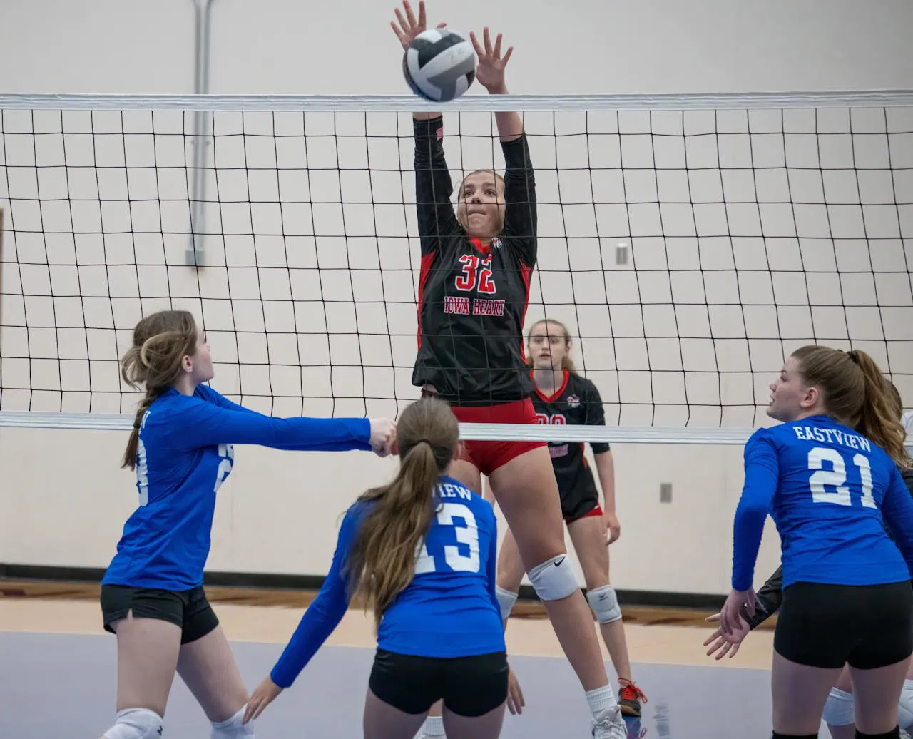 High school girls volleyball match in action, showcasing team competition and dynamic play.